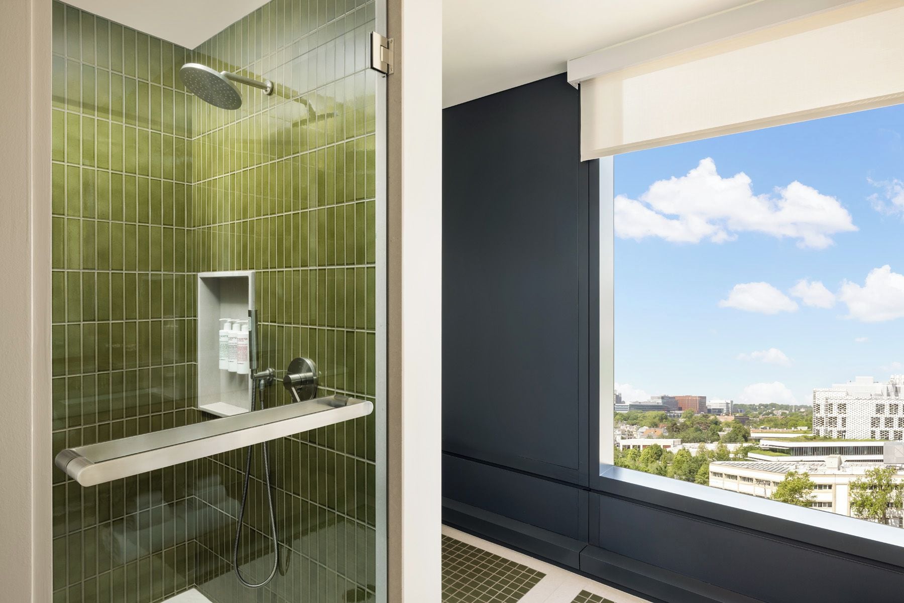 Ein modernes Badezimmer mit Duschkabine aus Glas, integriertem WC und einem Fenster mit Blick auf die Stadt.