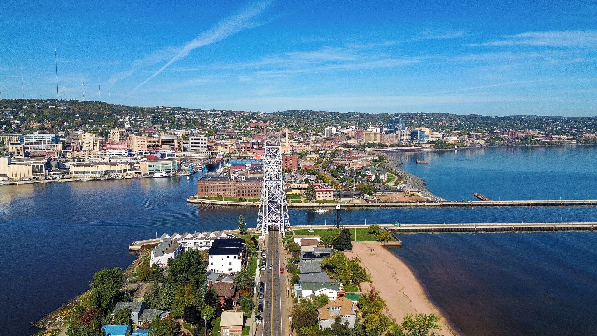 Rannikkokaupunki, jossa näkyy selvästi siluetti, huomiota herättävä silta, merenrantarakennuksia ja kirkas taivas.