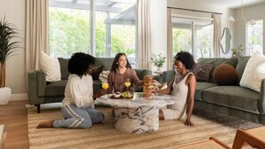 A living room with a round marble coffee table, a sofa, and a potted plant. - Desert Serenity: Pool, Sauna, Gym, Hot Tub, Bocce (Palm Springs)
