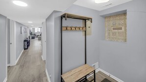 A hallway with a wooden bench, a coat rack, and a window with a decorative grid pattern. - Spacious 3 BDR/1 Bath - 1 mi from UChicago - Perfect for Traveling Professionals (Chicago)