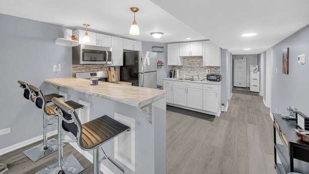 A modern kitchen with white cabinets, stainless steel appliances, and a wooden island. - Spacious 3 BDR/1 Bath - 1 mi from UChicago - Perfect for Traveling Professionals (Chicago)