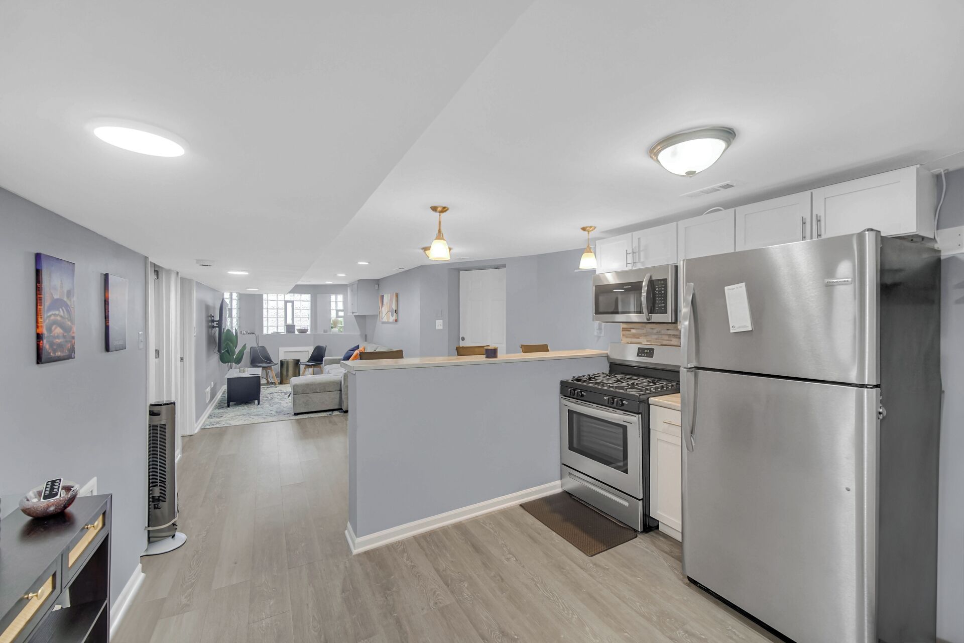 A modern kitchen with stainless steel appliances, a central island, and pendant lighting.