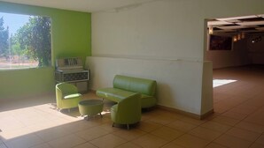 Una stanza con una parete verde, un divano, due poltrone, un tavolino e una radio.