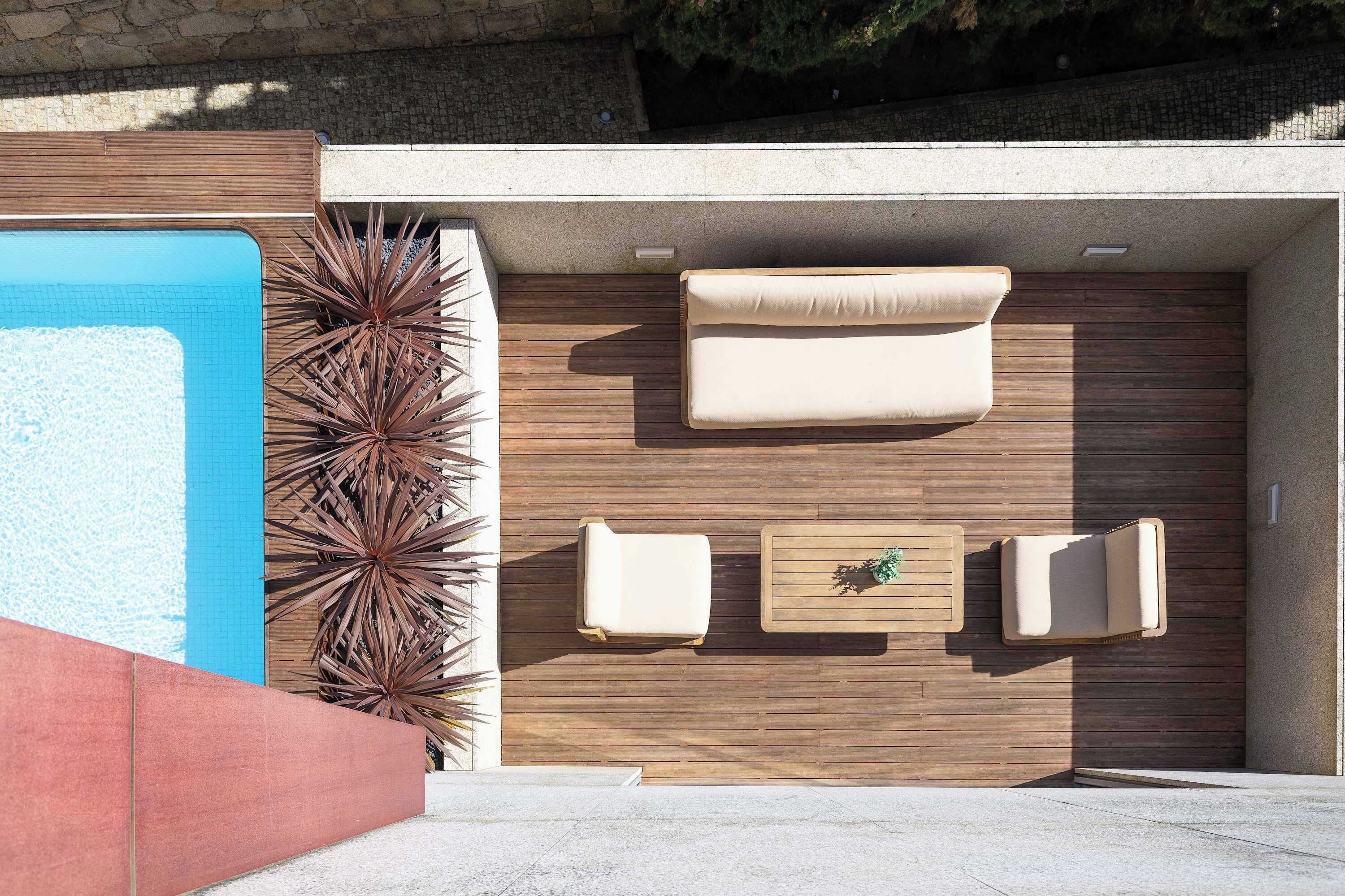 Un espace extérieur moderne aménagé avec des sièges, une piscine, un revêtement mural en bois et un mur en pierre.