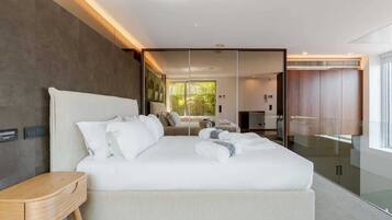 A modern bedroom with a large bed, a bedside table, and a wardrobe.