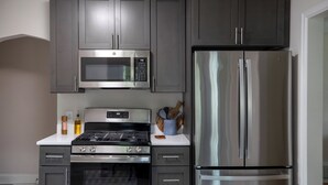 Una cocina moderna con electrodomésticos de acero inoxidable, incluyendo un microondas, horno y refrigerador.
