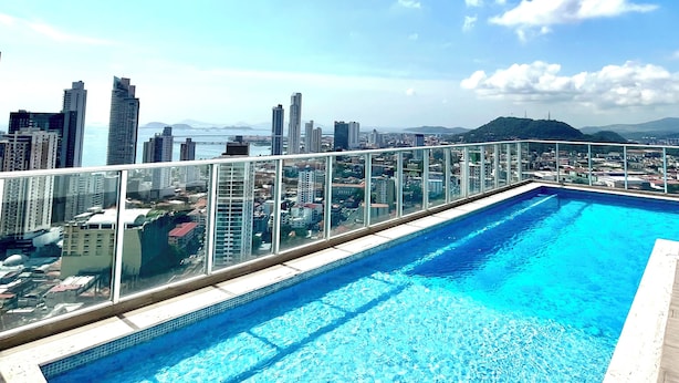 A rooftop pool with a city view, surrounded by high-rise buildings.