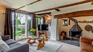 Una sala de estar acogedora con chimenea, televisor y comedor con mesa y sillas.