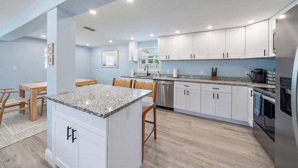 A modern kitchen with white cabinets, granite countertops, and stainless steel appliances. - Fresh Coastal Comfort, Beaches Close & Bay Views, 2 GB WIFI (Sarasota)