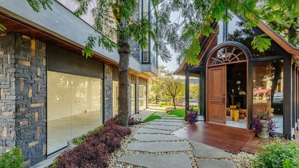 A modern house with a stone facade, a wooden deck, and a garden with a stone pathway. - Beautiful Apartments in Gramado - DMS (Gramado)