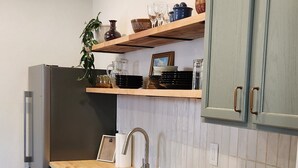 Una cocina moderna con gabinetes grises, encimera de madera y electrodomésticos de acero inoxidable.