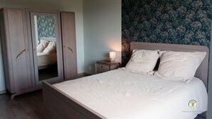 Ein Schlafzimmer mit Bett, Nachttisch und Kleiderschrank.