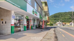 Een gebouw met een etalage waarop 'Franchising Brasil Farma' en 'Poupas Lojas' staat.