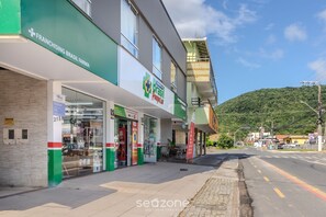 A building with a storefront labeled 'Franchising Brasil Farma' and 'Poupas Lojas'. - Studios in Barra in Balneario Camboriu - DPR (Balneário Camboriú)