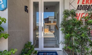 A hotel entrance with a glass door, a keypad, and a doormat. - Studios in Barra in Balneario Camboriu - DPR (Balneário Camboriú)