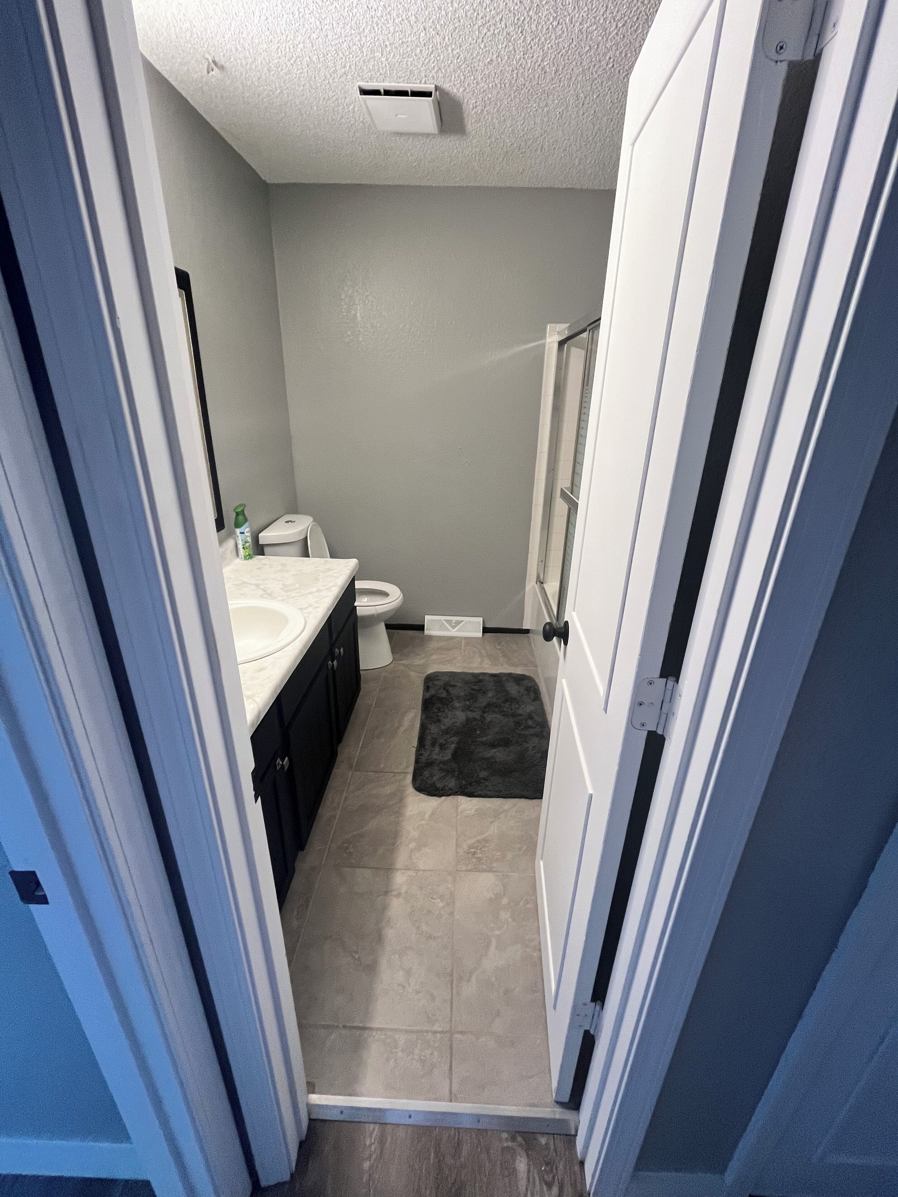A bathroom with a toilet, sink, and shower area.