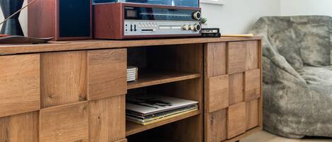 Un mueble de madera con un equipo de sonido antiguo y un tocadiscos.