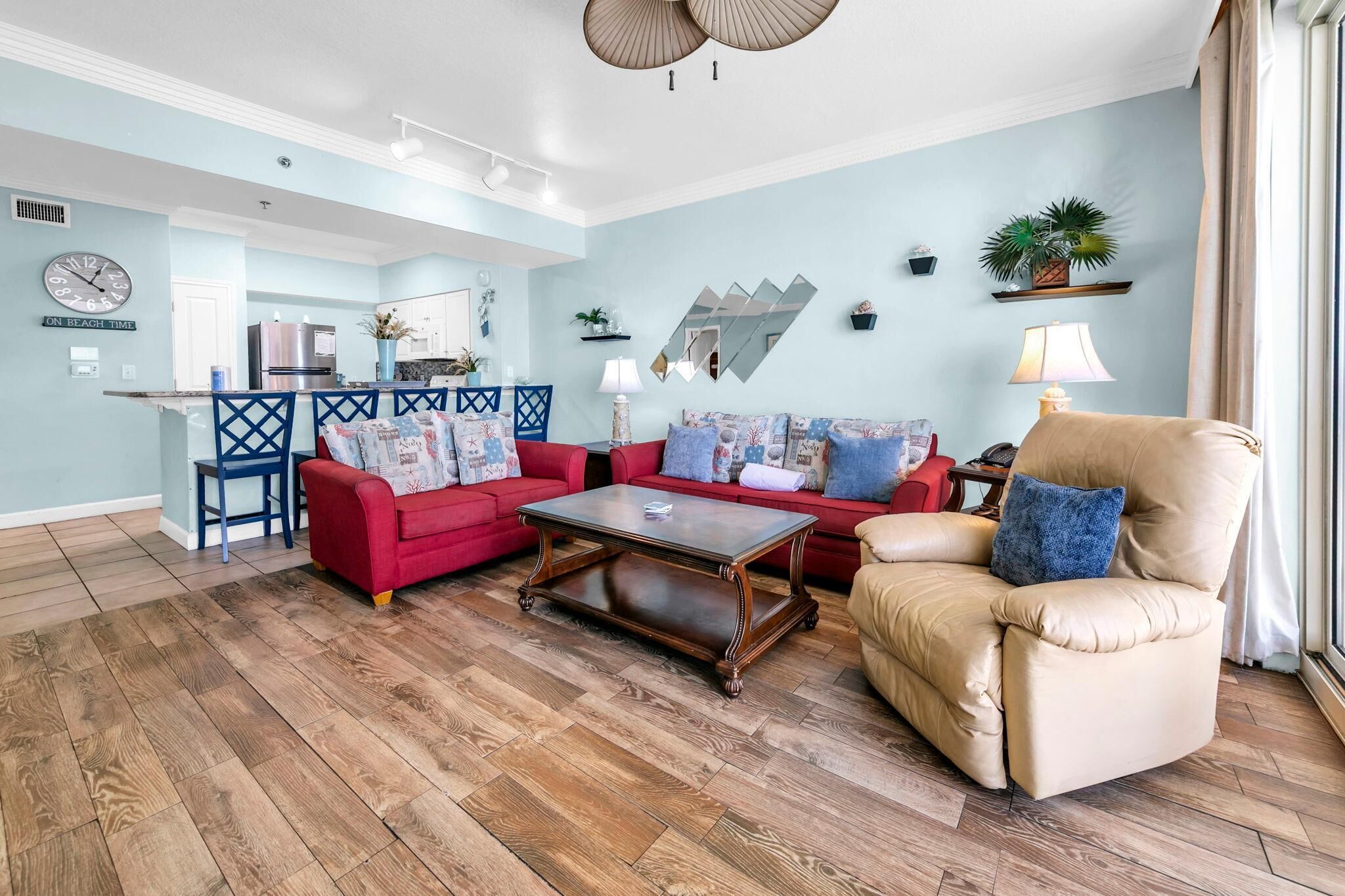 Ein Wohnzimmer mit rotem Sofa, beigem Sessel und Couchtisch.