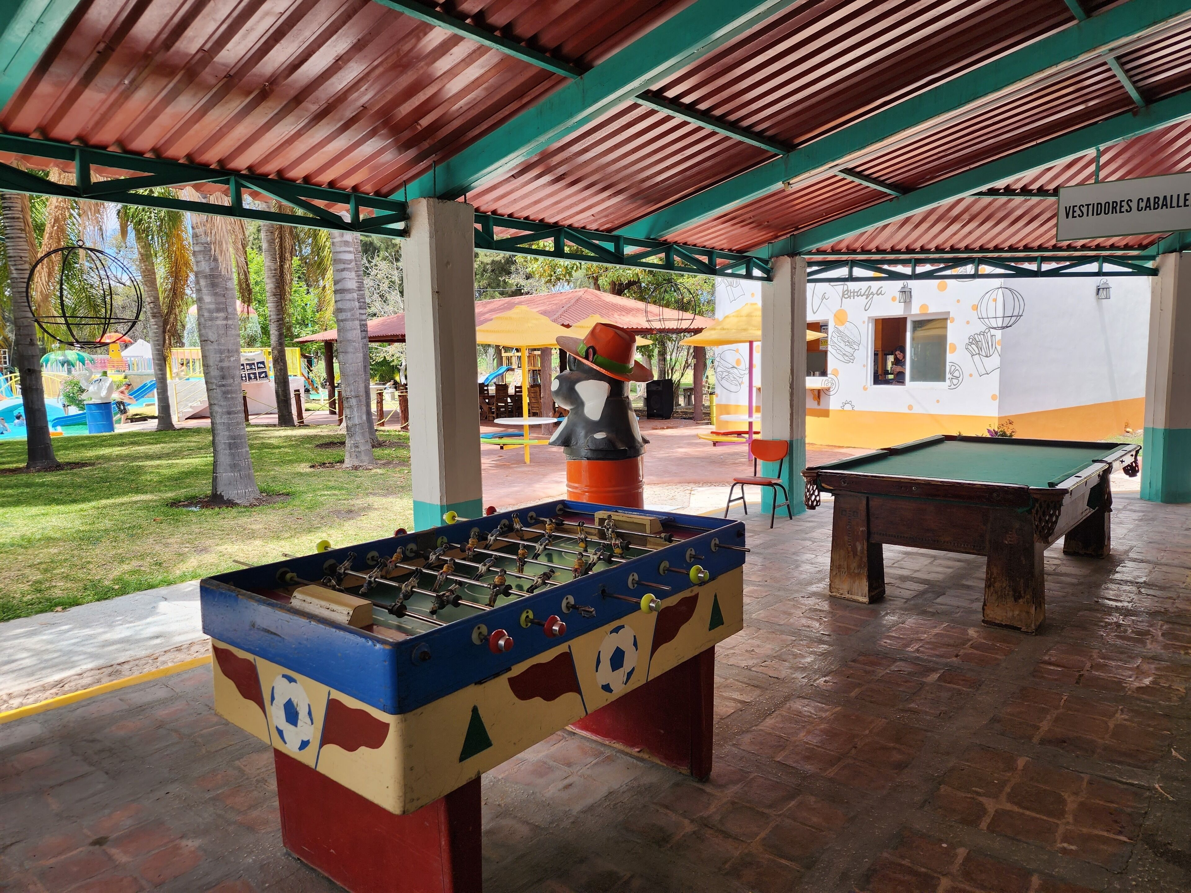 Un espace extérieur abrité comprenant une table de baby-foot et une table de billard.