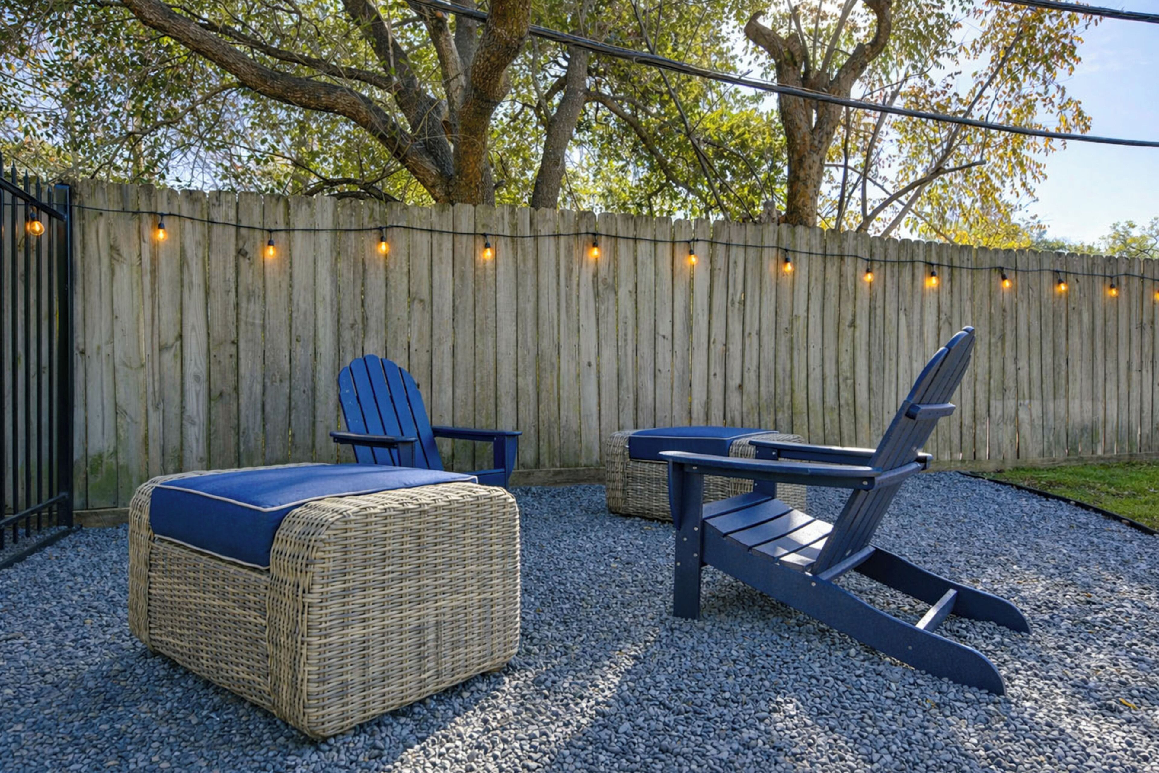 Een terras met rieten meubels en een houten omheining.