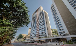 Un immeuble moderne de grande hauteur, doté de nombreux étages, de grandes fenêtres et d’un hall d’entrée imposant.