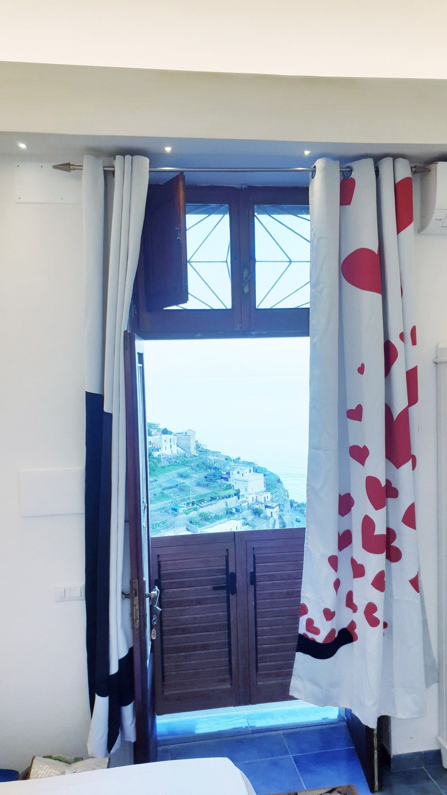 Una stanza con vista su una località costiera, una porta di legno e un letto.