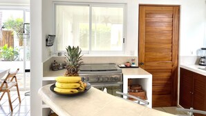 Eine moderne Küche mit einem großen Fenster, einem Herd und einer Holztür.