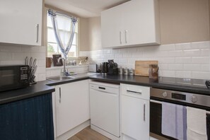 A kitchen with white cabinets, a black countertop, a dishwasher, an oven, and a window with blue curtains. - ※ Hidden Loft Apartment - Central Bath ※ (Bath)