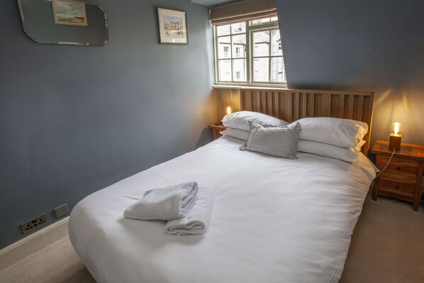 A neatly made bed with a folded towel, a wooden headboard, and bedside lamps. - ※ Hidden Loft Apartment - Central Bath ※ (Bath)