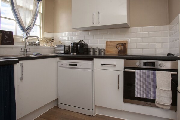 A modern kitchen with white cabinetry, a dishwasher, an oven, and a coffee maker. - ※ Hidden Loft Apartment - Central Bath ※ (Bath)