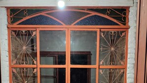 A large, ornate wooden door with intricate metal designs and a glass panel.