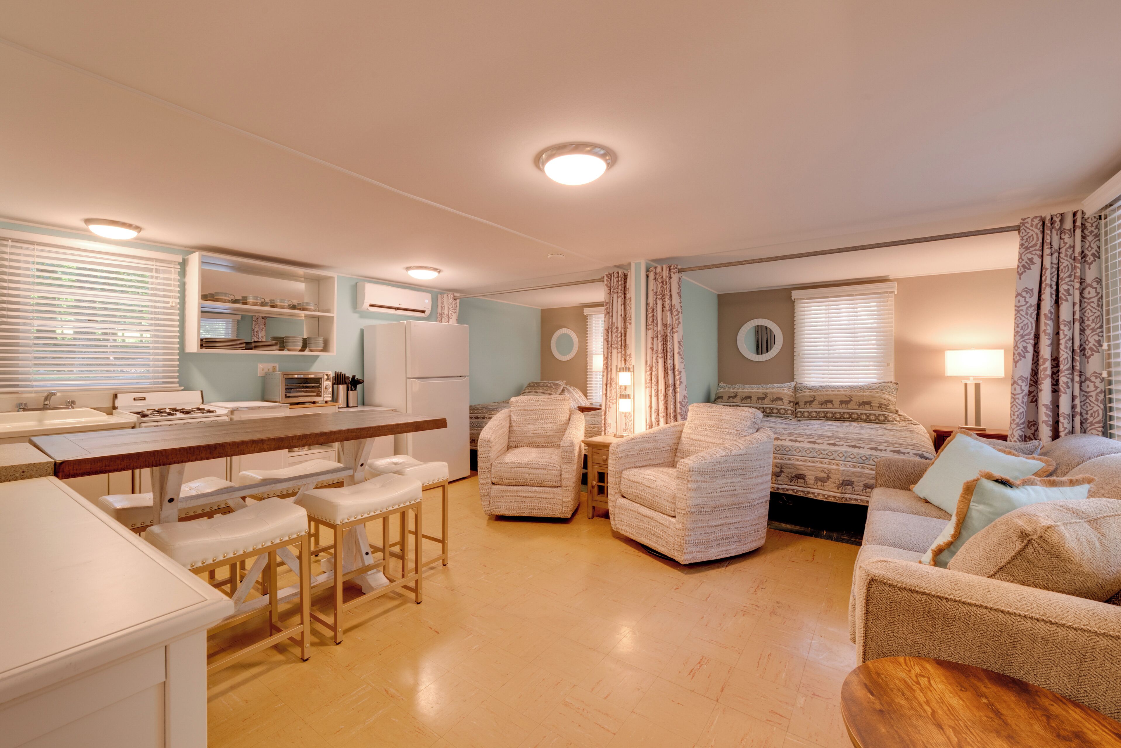 A compact living space with a kitchenette, a dining area, and a sofa set.