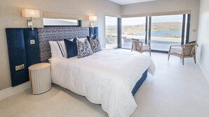 A modern bedroom with a large bed, a view of the outdoors, and a balcony. - ATLANTIC SEA BREEZE, pet friendly in Gortahork, County Donegal (Falcarragh)
