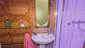 A wooden cabin bathroom with a sink, mirror, and shower. - RIVER VIEW POD, pet friendly, with open fire in Muff, County Donegal (Muff)