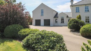 A two-story house with a driveway leading to a garage.