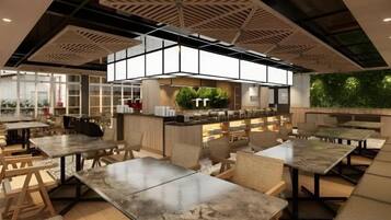 A modern restaurant with high ceilings, a central kitchen, and outdoor seating.