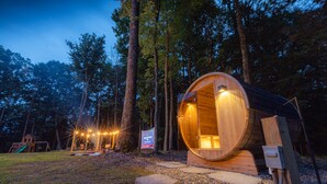 Una cabaña de madera con interior circular, rodeada por un bosque.