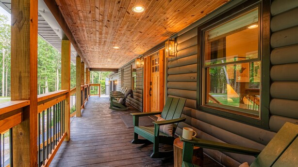 Una terraza de madera con bancos y vistas a un bosque.
