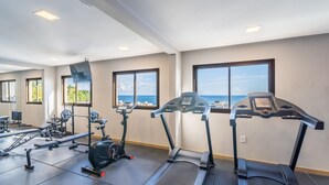 A gym with treadmills, a stationary bike, and weight machines. -  Apartamentos em Prédio c/Academia na Ondina-SSA-HOA (Salvador)