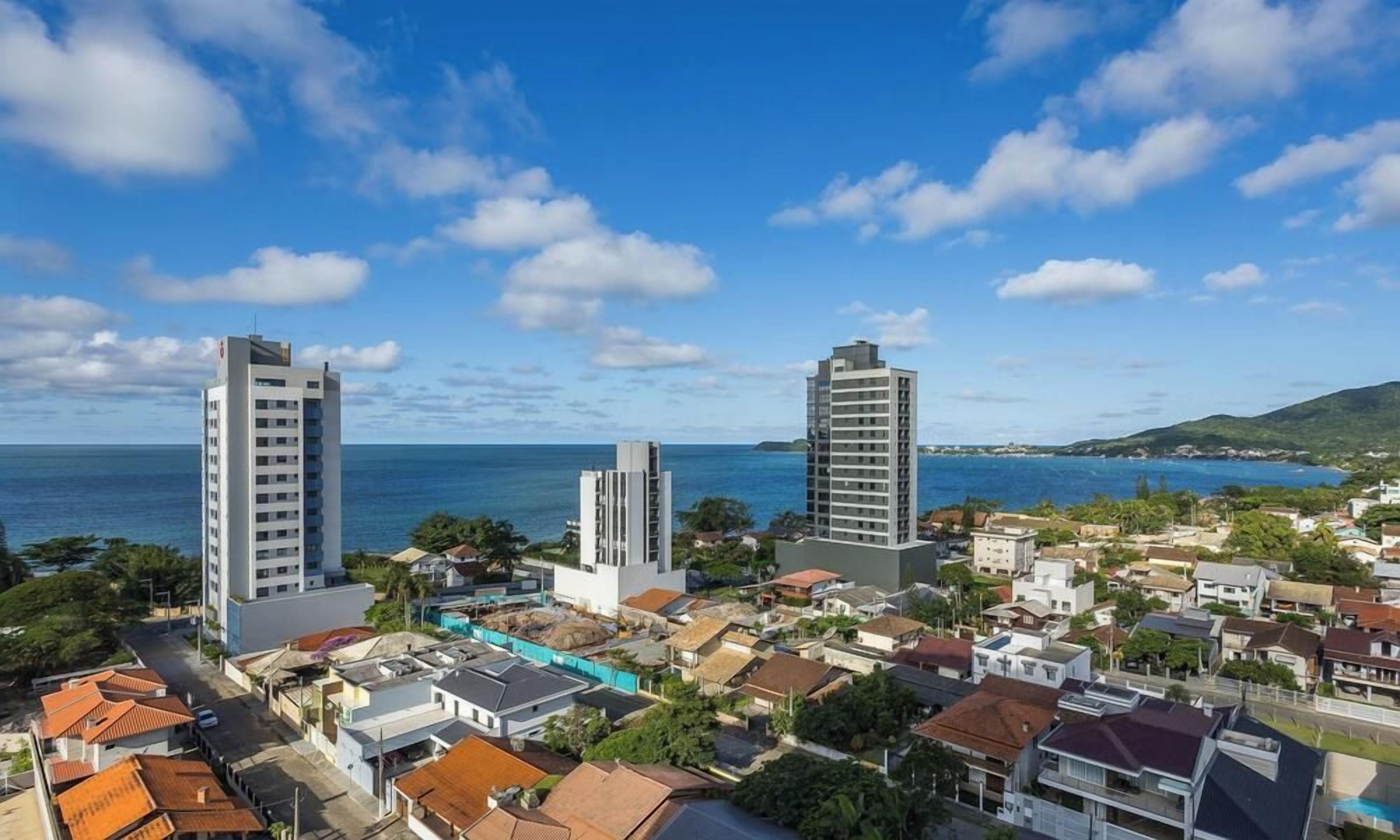 A coastal residential area with modern buildings and a clear view of the sea.
