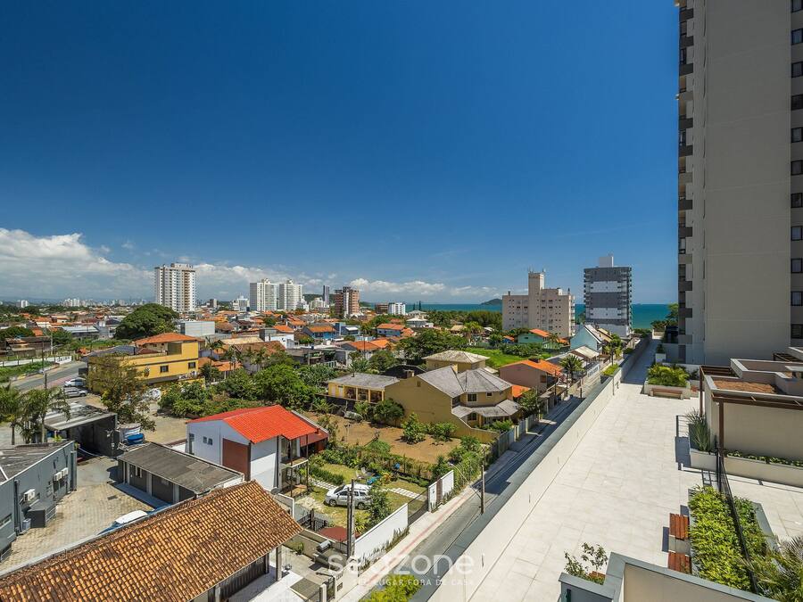 A residential area with a mix of buildings, including a tall apartment building and smaller houses, with a clear sky above.