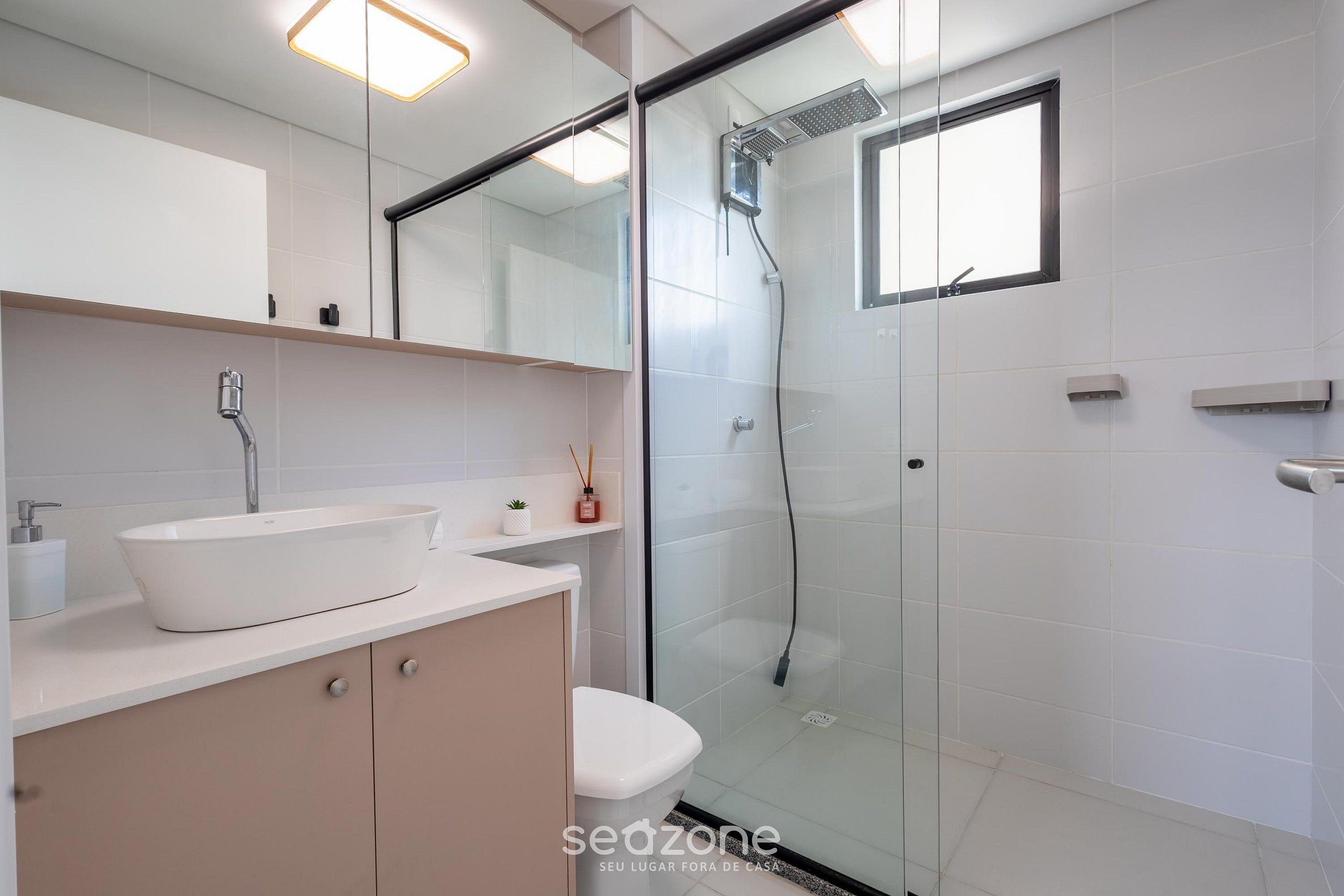 A modern bathroom with a glass-enclosed shower, a white sink, and a toilet.