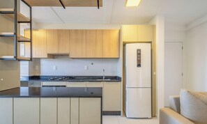 Una cocina moderna con una isla central, electrodomésticos integrados y un diseño minimalista.