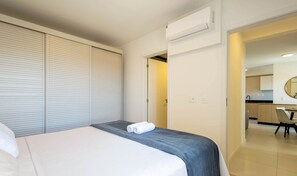 Une chambre d’hôtel équipée d’un lit, d’une armoire, d’un appareil de climatisation et donnant sur la cuisine.