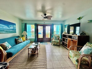A living room with a sofa, coffee table, and a television.