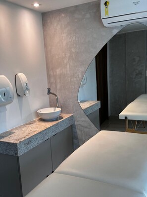 A modern bathroom with a granite countertop, a white sink, a hand dryer, and a mirror. - Sunny Hall - V.S.H. (Ipojuca)