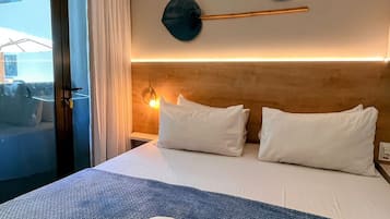 Quarto de hotel com uma cama, almofadas, um cobertor azul texturizado e um par de toalhas.