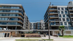 A modern residential building with multiple balconies and large windows. - Cond Apartments Vila do Lago in Jurere - VLO (Florianópolis)