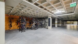 A bicycle storage area with multiple bikes and a sign indicating 'SAÍDA' (exit). - Cond Apartments Vila do Lago in Jurere - VLO (Florianópolis)