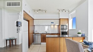 Een moderne keuken met houten kastjes, roestvrijstalen apparatuur en een centraal keukenblok.